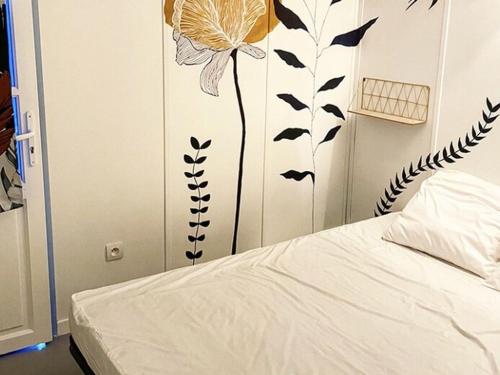 a bedroom with a bed with a flower on the wall at Maison agréable - 6 pers. - API-1-52-2148 in Lattes