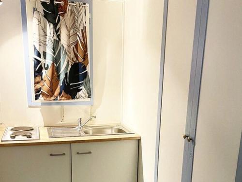 a small kitchen with a sink and a mirror at Maison agréable - 6 pers. - API-1-52-2148 in Lattes