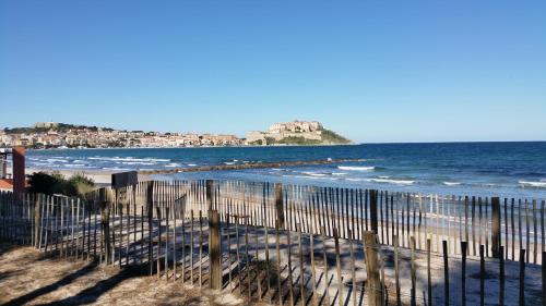a beach with a fence and some boats on it at Camping Dolce Vita in Calvi