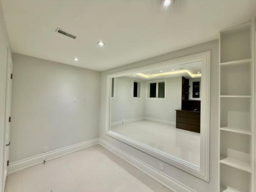 a room with white walls and a large mirror at Modern Luxury Living in Toronto