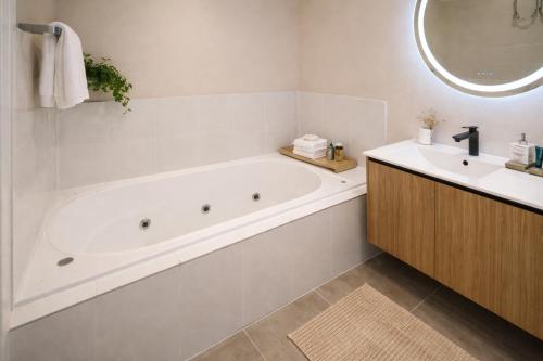 a white bathroom with a tub and a sink at De'Vine Escape in Dixons Creek