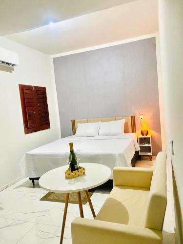 a bedroom with a bed and a table with a bottle of champagne at Refugio tropical icarai in Icaraí