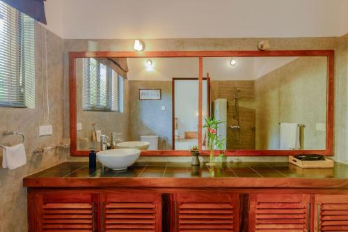 a bathroom with a sink and a large mirror at The Glasshouse Victoria in Digana