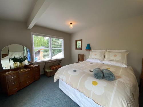a bedroom with a bed with two stuffed animals on it at Omarama township location - how good! in Omarama