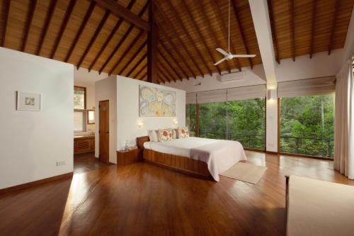 a large bedroom with a bed and large windows at The Glasshouse Victoria in Digana