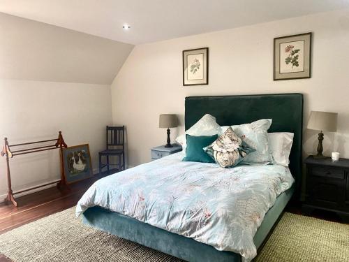 a bedroom with a bed with a green headboard and pillows at The Secret Garden Burradoo in Burradoo