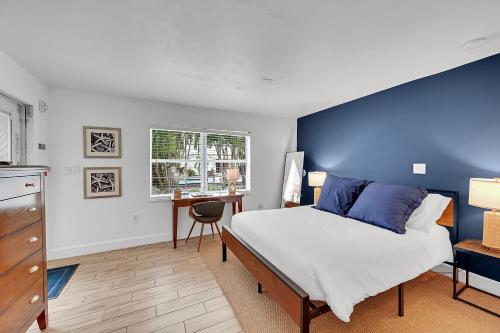 a bedroom with a large bed with a blue wall at Inn On The Drive in Fort Lauderdale