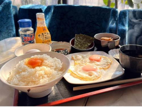 a tray of food with rice and eggs on a table at Asahikan in Kofu