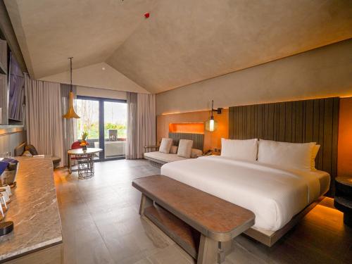 a bedroom with a large bed and a living room at Amorita Resort Palawan in Puerto Princesa