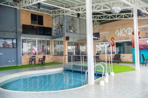 a large building with a swimming pool in front of it at Hotel Calima Real in Cali
