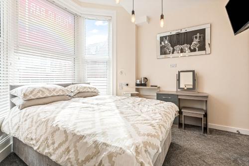 a bedroom with a bed and a desk and a window at The B & B Blackpool in Blackpool