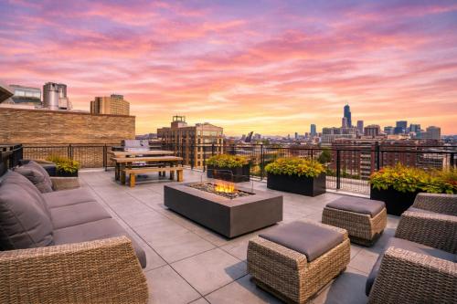 a rooftop patio with furniture and a view of the city at Bright 2BR Apt with Gym and Optional Parking Near Soldier Field, Museum Campus, McCormick Place in Chicago