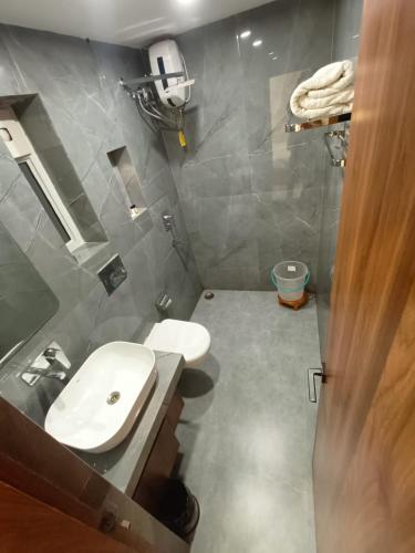 a bathroom with a white toilet and a sink at HOTEL LAWANG SIGNAGE in Deoghar