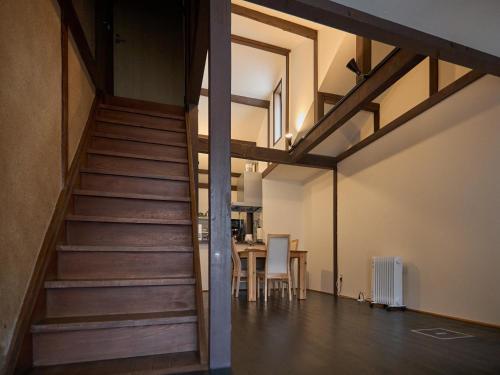 a staircase in a room with a table and chairs at Villa near Kinkakuji Pets OK free Parking 金閣寺周辺 貸切町屋 ペットOK 無料駐車場 in Kinugasa