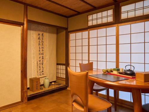a dining room with a table and chairs and windows at Villa near Kinkakuji Pets OK free Parking 金閣寺周辺 貸切町屋 ペットOK 無料駐車場 in Kinugasa