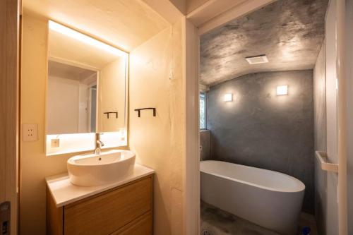 a bathroom with a sink and a bath tub at 将軍の隠れ家 in Okayama