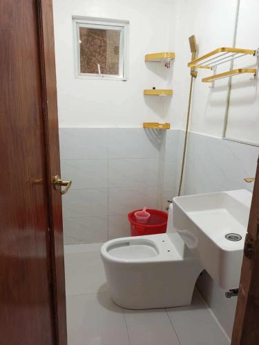 a white bathroom with a toilet and a sink at M3 Haven Masbate in Masbate