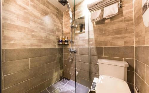 a bathroom with a toilet and a glass shower at Hotel Piano in Seoul