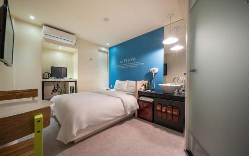 a bedroom with a large bed and a sink at Hotel Piano in Seoul