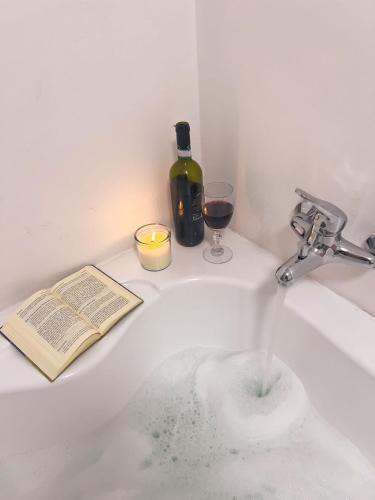 a sink with a book and a glass of wine at La Bergerie Isolabella sea view B & B in Taormina