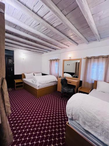 a hotel room with two beds and a mirror at Hotel Dancing Yak in Jomsom
