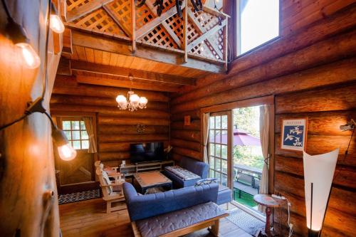 a living room with a blue couch in a log cabin at Forest Villa Rio Biwako in Takashima