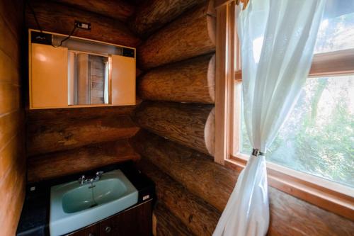 a bathroom with a sink and a window at Forest Villa Rio Biwako in Takashima