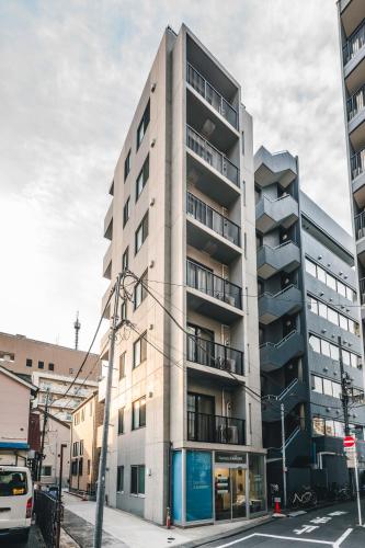 a tall apartment building on a city street at Gamadas BLD in Tokyo