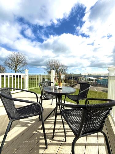 a patio with four chairs and a table on a deck at Cedar Retreat in Scarborough
