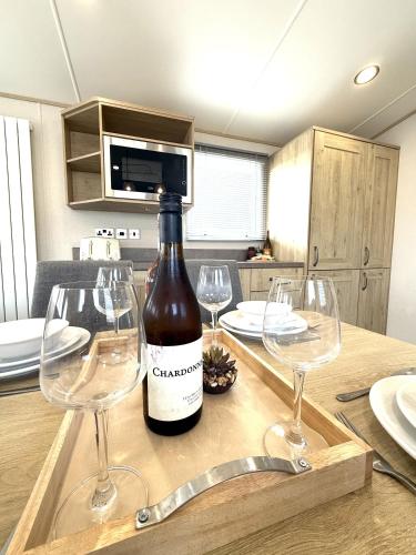 a bottle of wine sitting on a table with wine glasses at Cedar Retreat in Scarborough