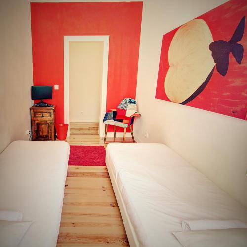a bedroom with two beds and a red wall at We Love F Tourists in Lisbon