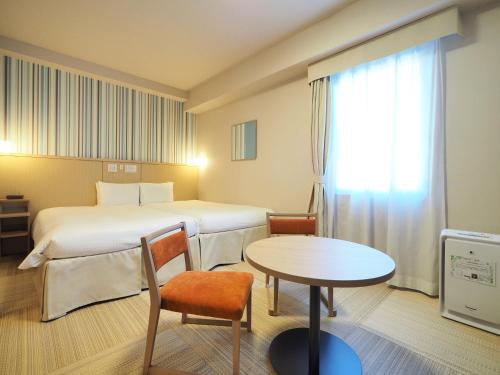 a hotel room with a bed and a table at Hiyori Hotel Maihama in Urayasu