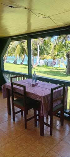 a table with two chairs and a purple table cloth on it at Knox's Beachfront Homestay in Nalauwaki