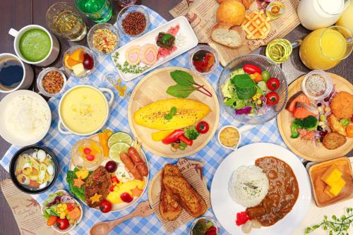 a table with many plates of food on it at Hiyori Hotel Maihama in Urayasu