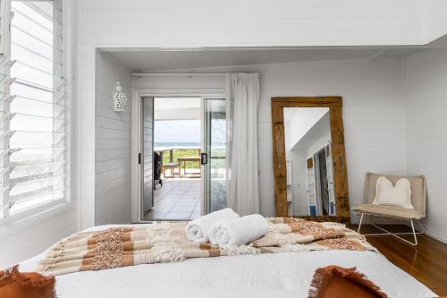 a bedroom with a bed with a view of the ocean at The Beach House in Lennox Head