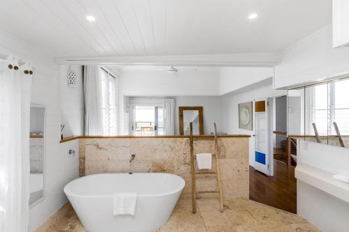 a bathroom with a large white tub in it at The Beach House in Lennox Head