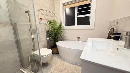 a bathroom with a tub and a toilet and a sink at Blue-breaker view in Struisbaai