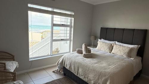 a bedroom with a bed with a view of the ocean at Blue-breaker view in Struisbaai