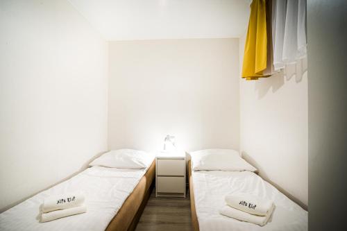 two twin beds in a small room with white walls at Domek Parterowy in Gąski