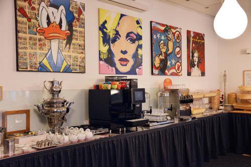 a counter in a room with paintings on the wall at Arthotel Munich in Munich