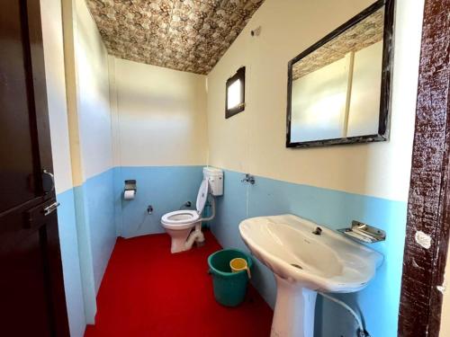 a bathroom with a toilet and a sink and a mirror at zoz camp pangong lake in Lukung