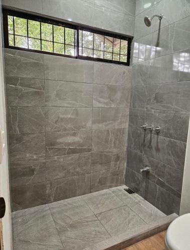a bathroom with a shower with a glass door at Cabañas y Senderos Finca El Triunfo in Los Chiles