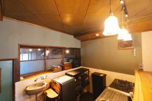 a small kitchen with a sink and a stove at oribe guesthouse in Tajimi