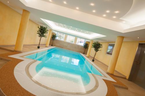 a large swimming pool in a room with columns at Moin Hotel Cuxhaven in Cuxhaven