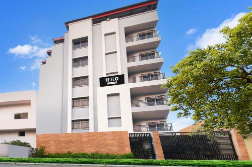 a white building with a black sign on it at Hotel O Raipur City Center Formerly South Inn in Raipur