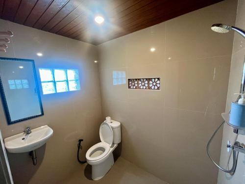 a bathroom with a toilet and a sink at Pondok Kayu Pathavi in Baturiti
