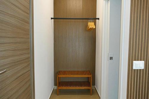 a walk in shower with a wooden bench in a room at Coco'S Rooms in Bari Palese