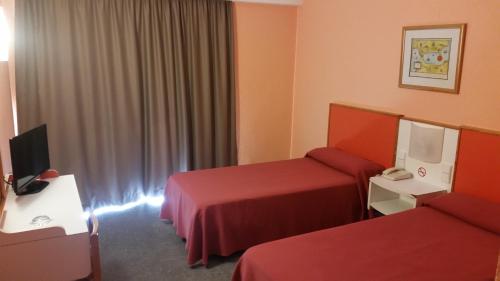 een hotelkamer met 2 bedden en een televisie bij Mont-Park in Benidorm