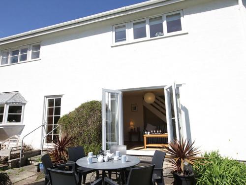 a white house with tables and chairs in front of it at Bwthyn y Mor in Porthmadog