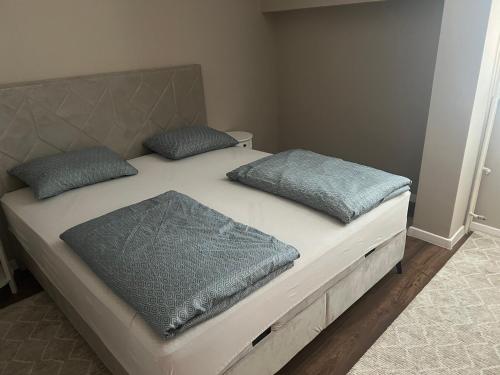 a bed with two pillows on top of it at Apartman Novak Prijedor in Prijedor